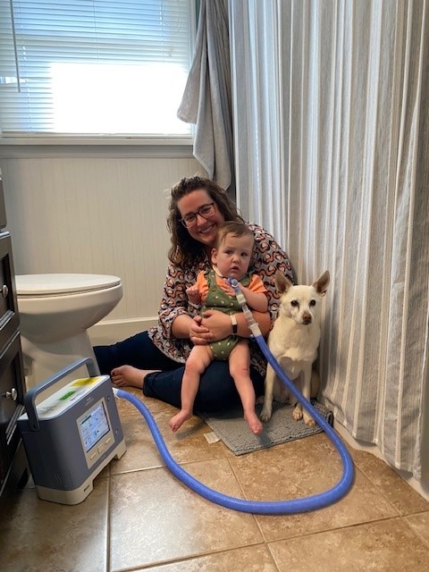 Child and caregiver with dog sheltered in bathroom