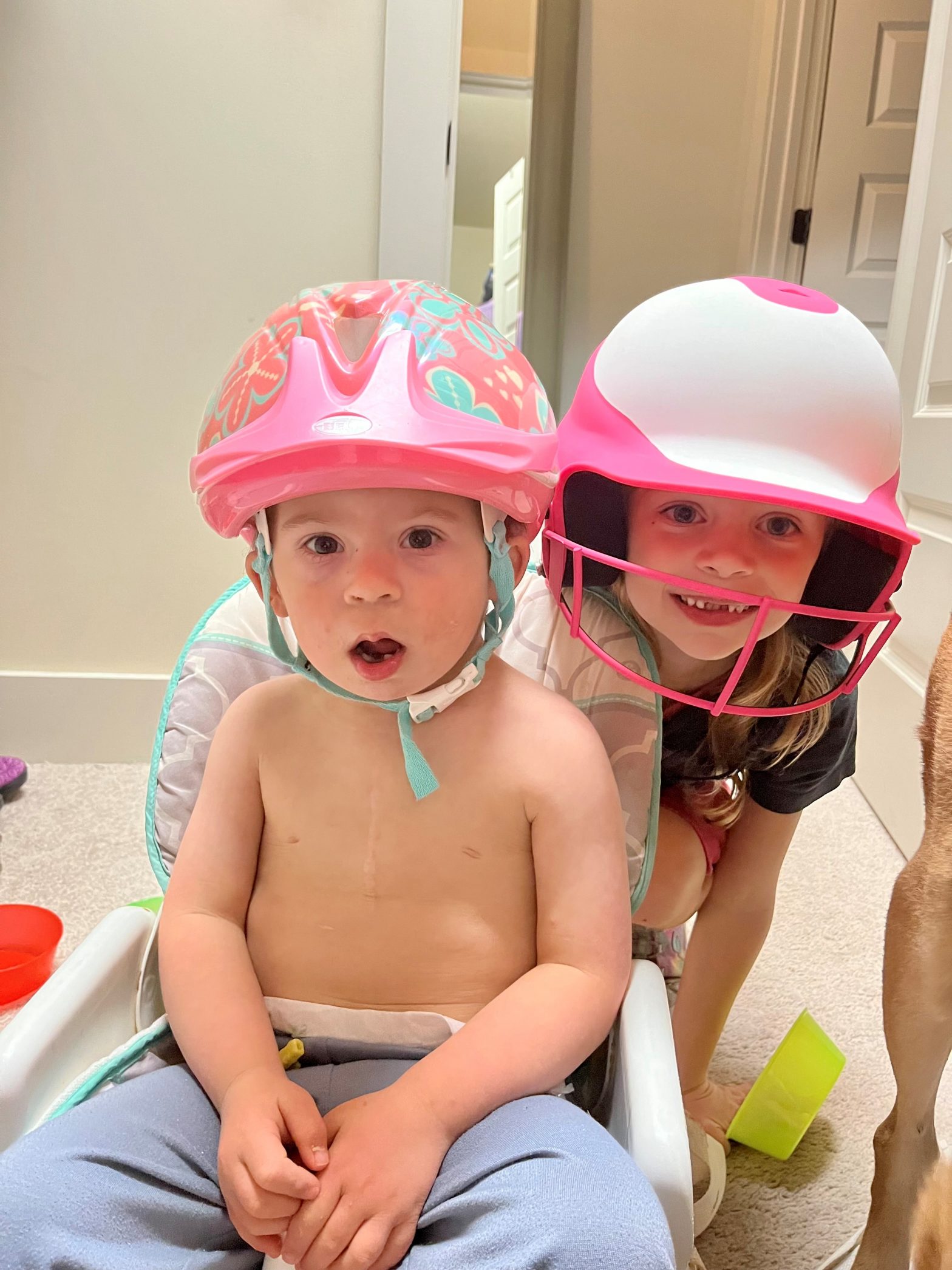 Two children demonstrate wearing helmets during a weather emergency