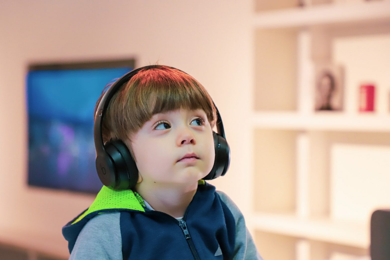 Child with headphones looking expectantly at an adult offscreen